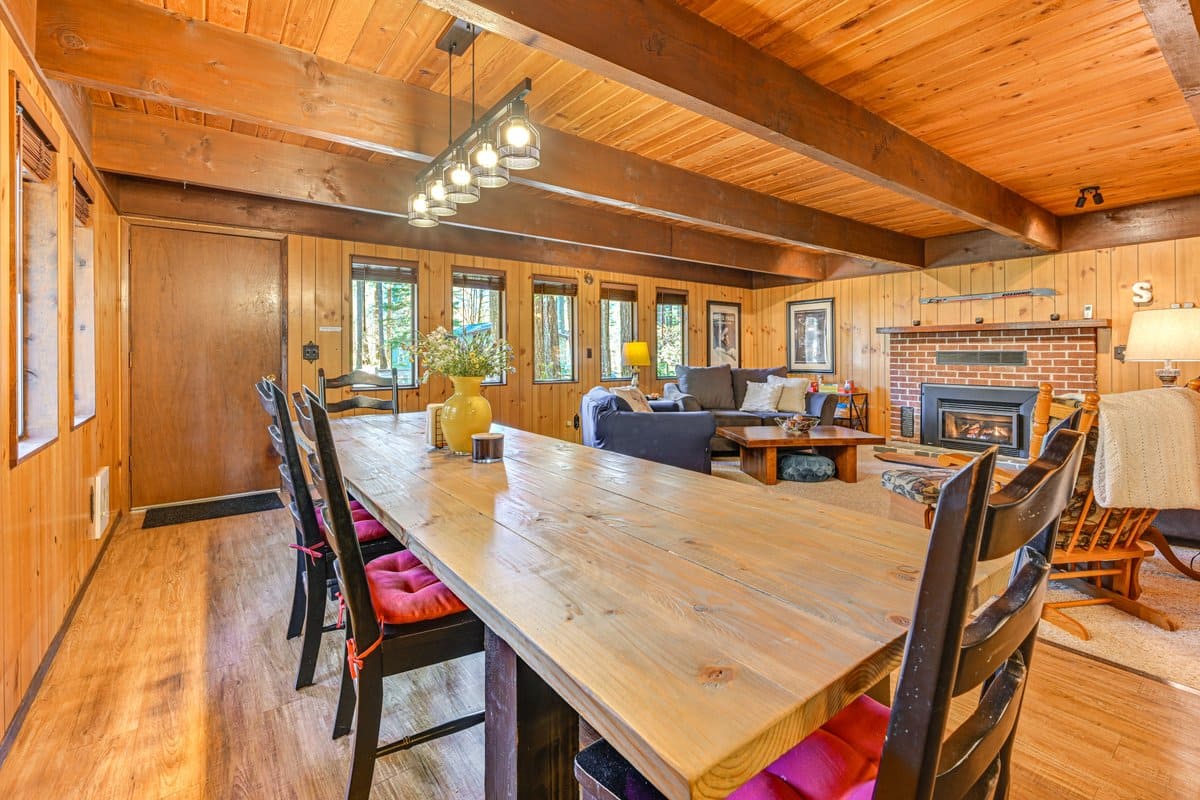 Wood-paneled dining and living room with fireplace